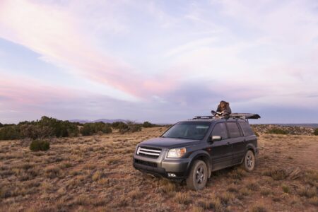 children on SUV at sunset, Galisteo Basin, Santa Fe, NM.